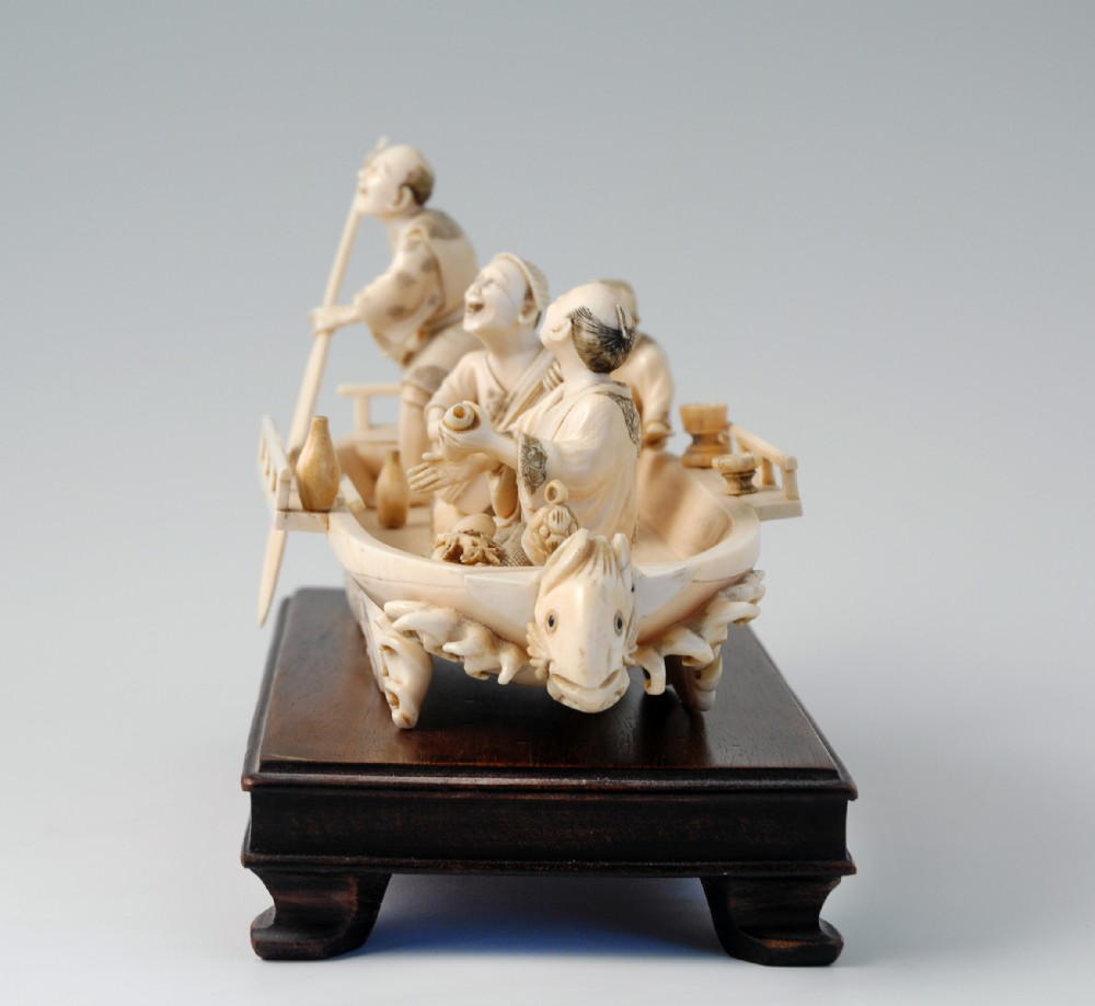 A HUMEROUS JAPANESE IVORY OKIMONO PLEASURE BOAT SIGNED 