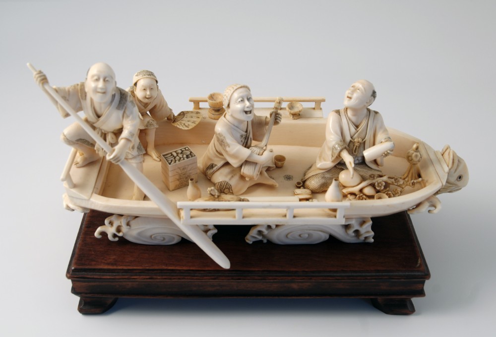 A HUMEROUS JAPANESE IVORY OKIMONO PLEASURE BOAT SIGNED 