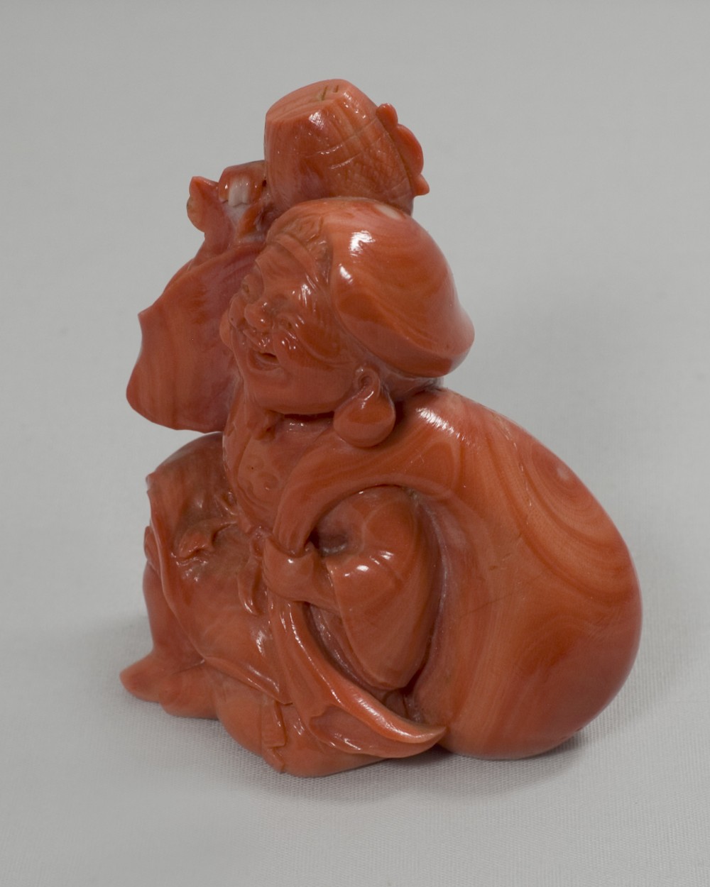 A RARE JAPANESE CARVED CORAL OKIMONO OF DAIKOKU View II