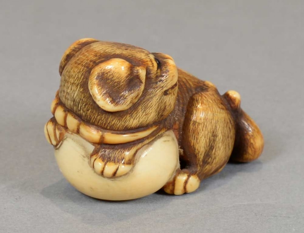a charming japanese edo period ivory netsuke of a puppy dog clutching a ball - CATEGORY: ANTIQUE MISCELLANEOUS - DATED 1850