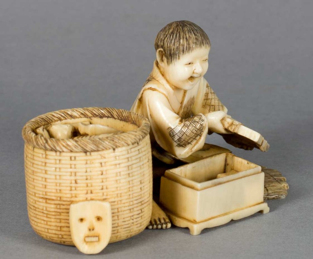 A FUN JAPANESE IVORY OKIMONO OF A BOY WITH HIS TOYS View II