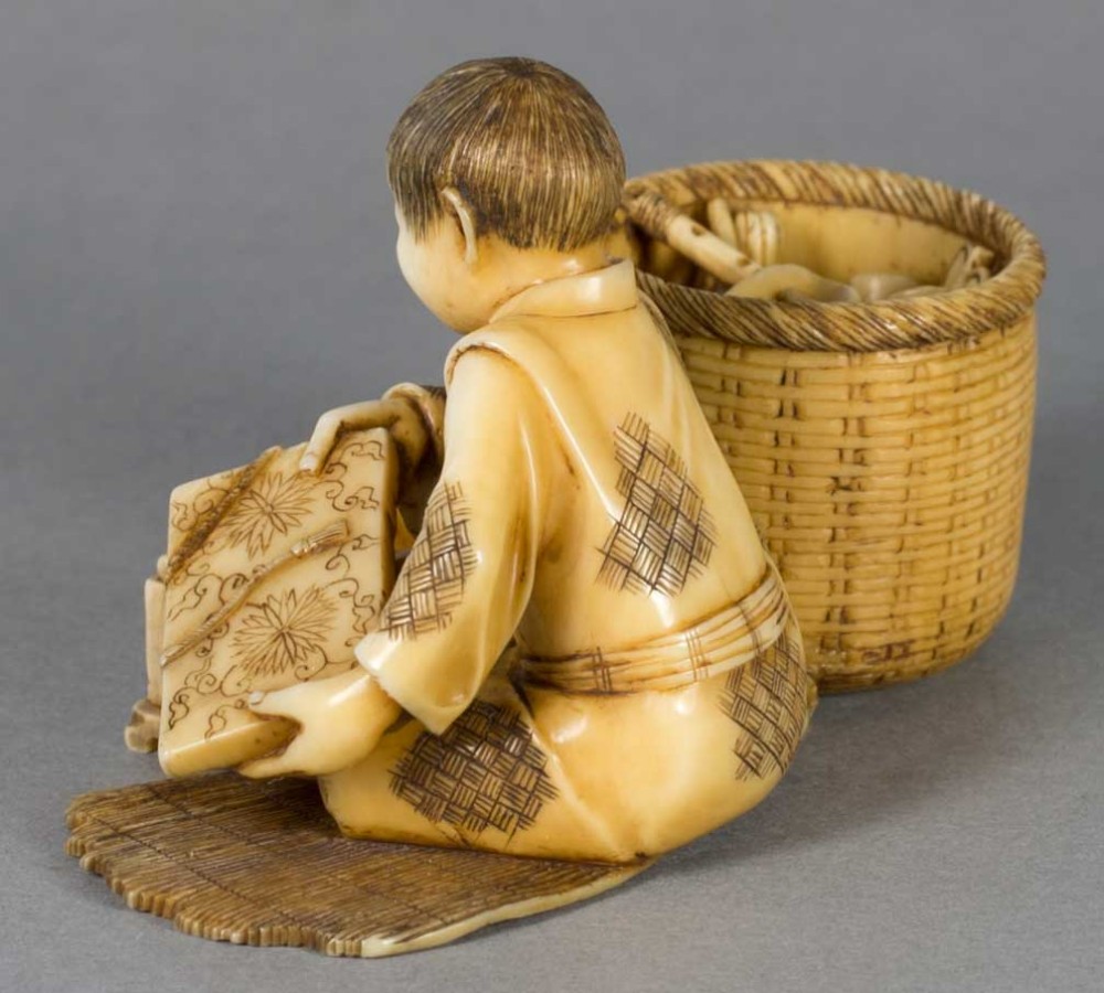 A FUN JAPANESE IVORY OKIMONO OF A BOY WITH HIS TOYS View IV