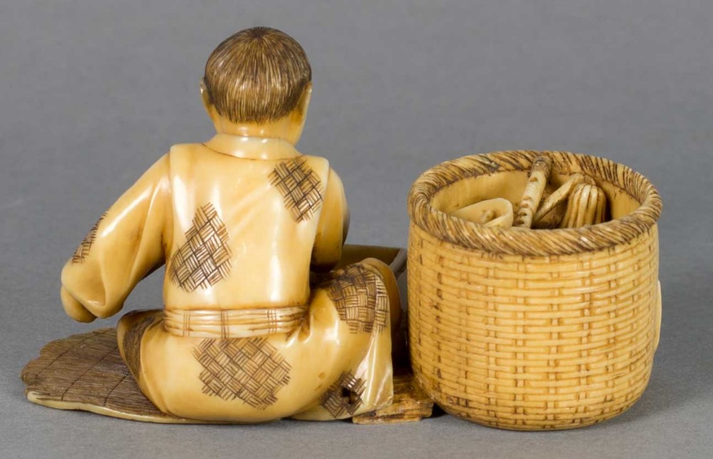 A FUN JAPANESE IVORY OKIMONO OF A BOY WITH HIS TOYS View V