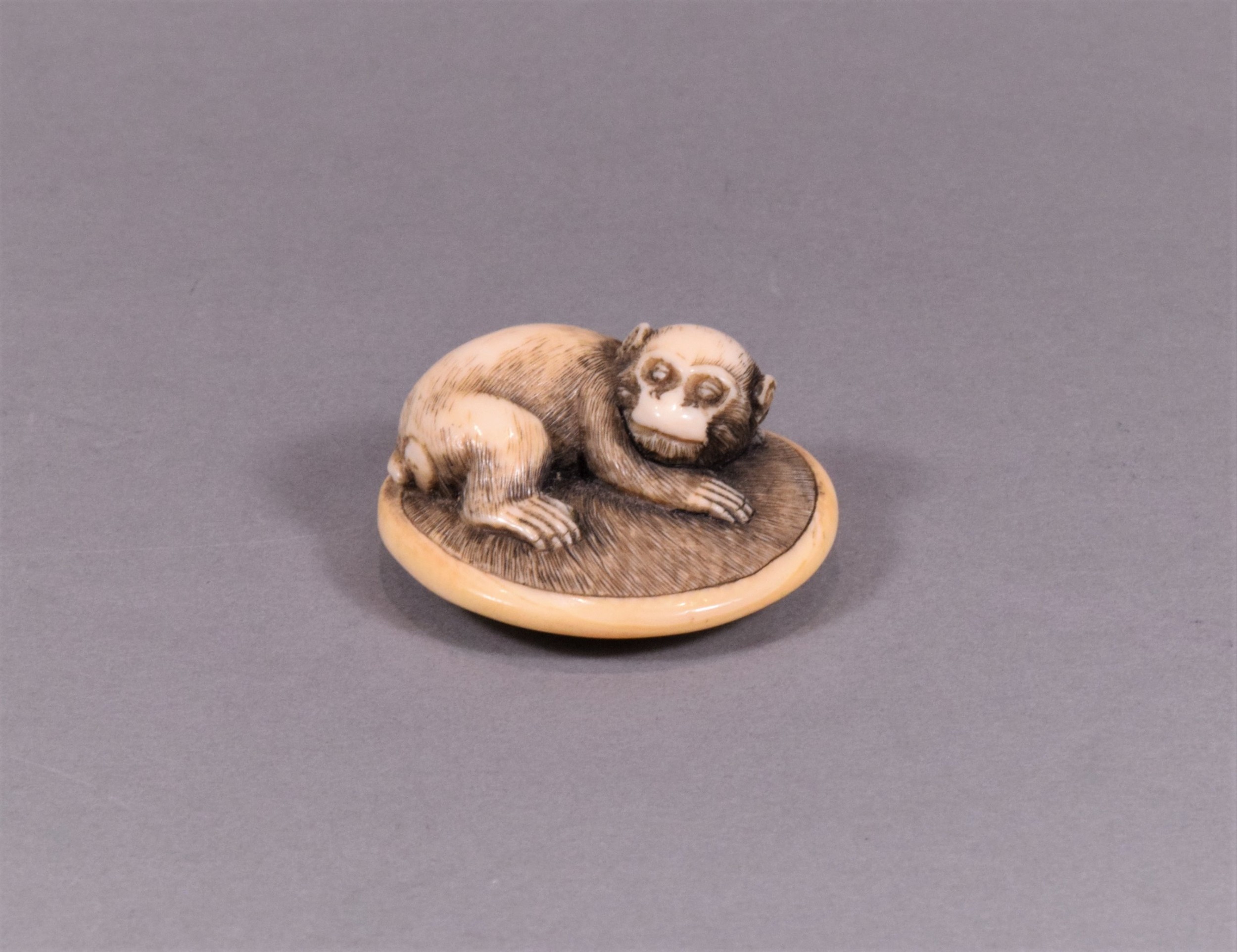 A CHARMING JAPANESE EDO PERIOD IVORY NETSUKE - MONKEY UPON ON A ZABUTON View III