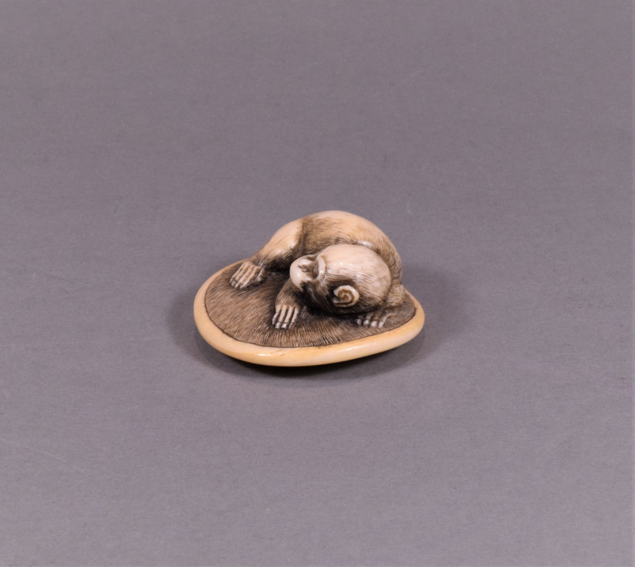 A CHARMING JAPANESE EDO PERIOD IVORY NETSUKE - MONKEY UPON ON A ZABUTON View V