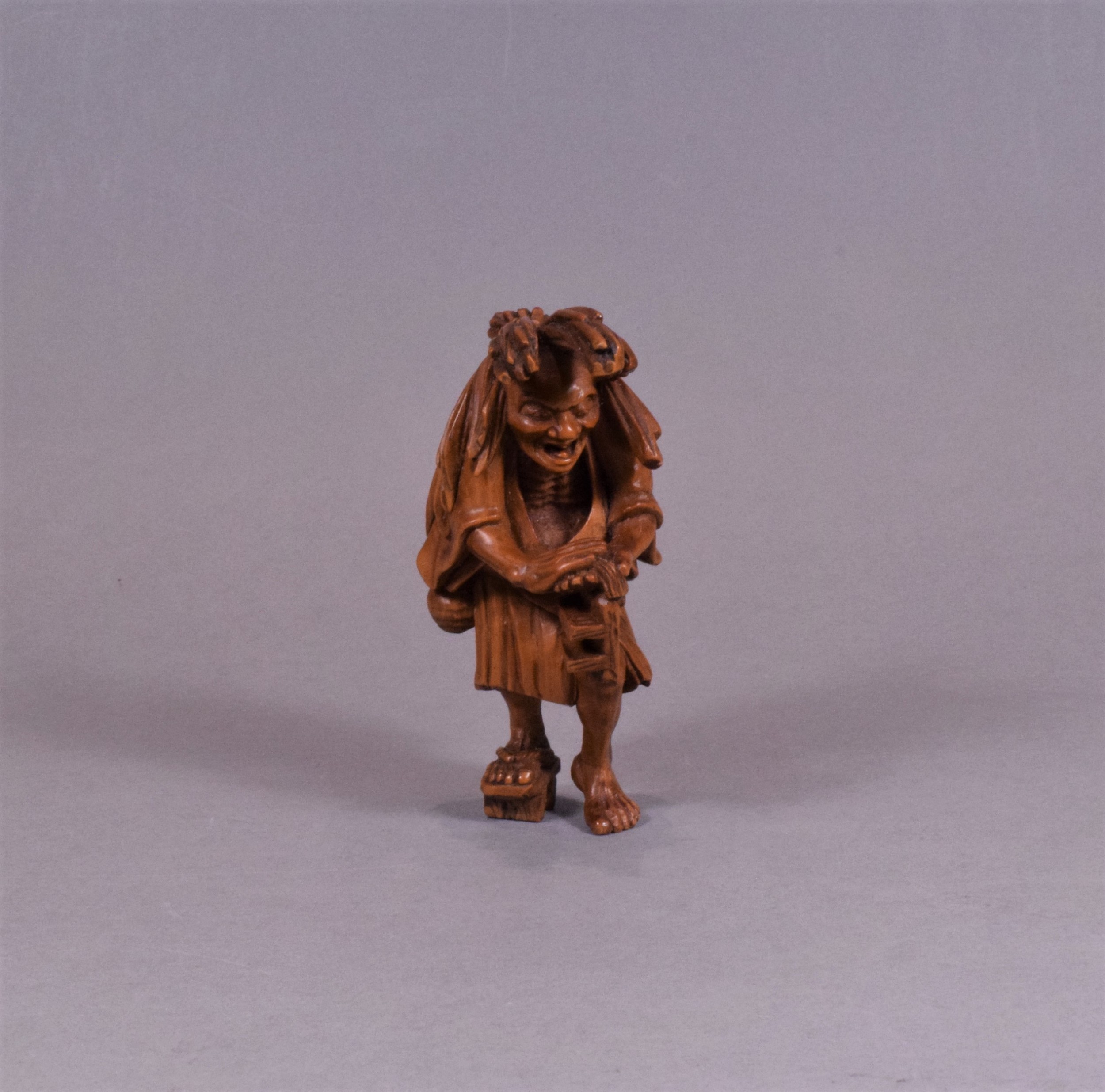 A WELL CARVED JAPANESE CARVED WOODEN NETSUKE - ABURA BOZU - THE OIL THIEF View II