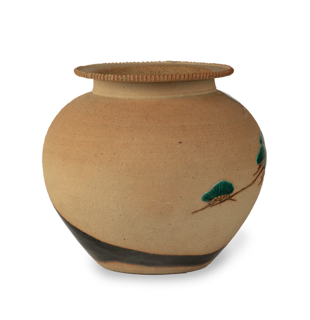 A rounded Japanese stoneware jardiniere crafted in buff clay with relief carvings of white cranes perched on green pine branches. View II