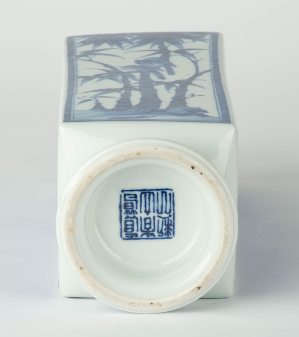 A tall quadrangular Japanese porcelain vase decorated with underglaze cobalt blue landscape scenes and geometric panels on a white ground. View IX