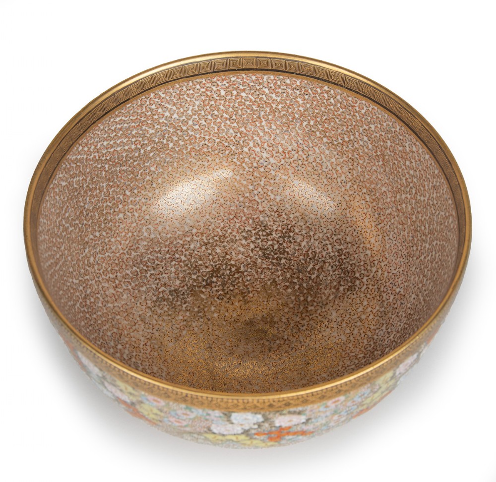 A deep Japanese Satsuma earthenware bowl featuring densely painted floral chrysanthemums, insect motifs near the base, and gilded borders on a cream background. View V