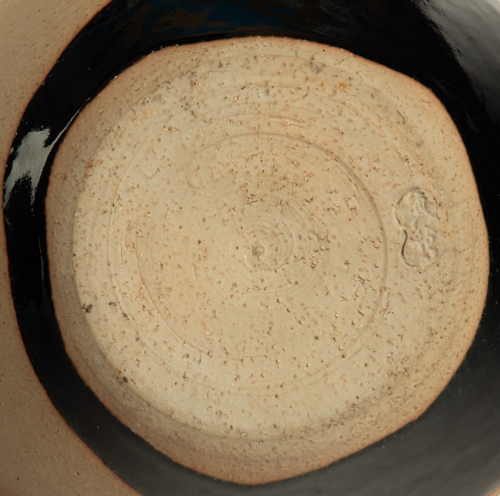 A rounded beige stoneware jardiniere decorated with high-relief green pine branches and white cranes above a black band base. View VII