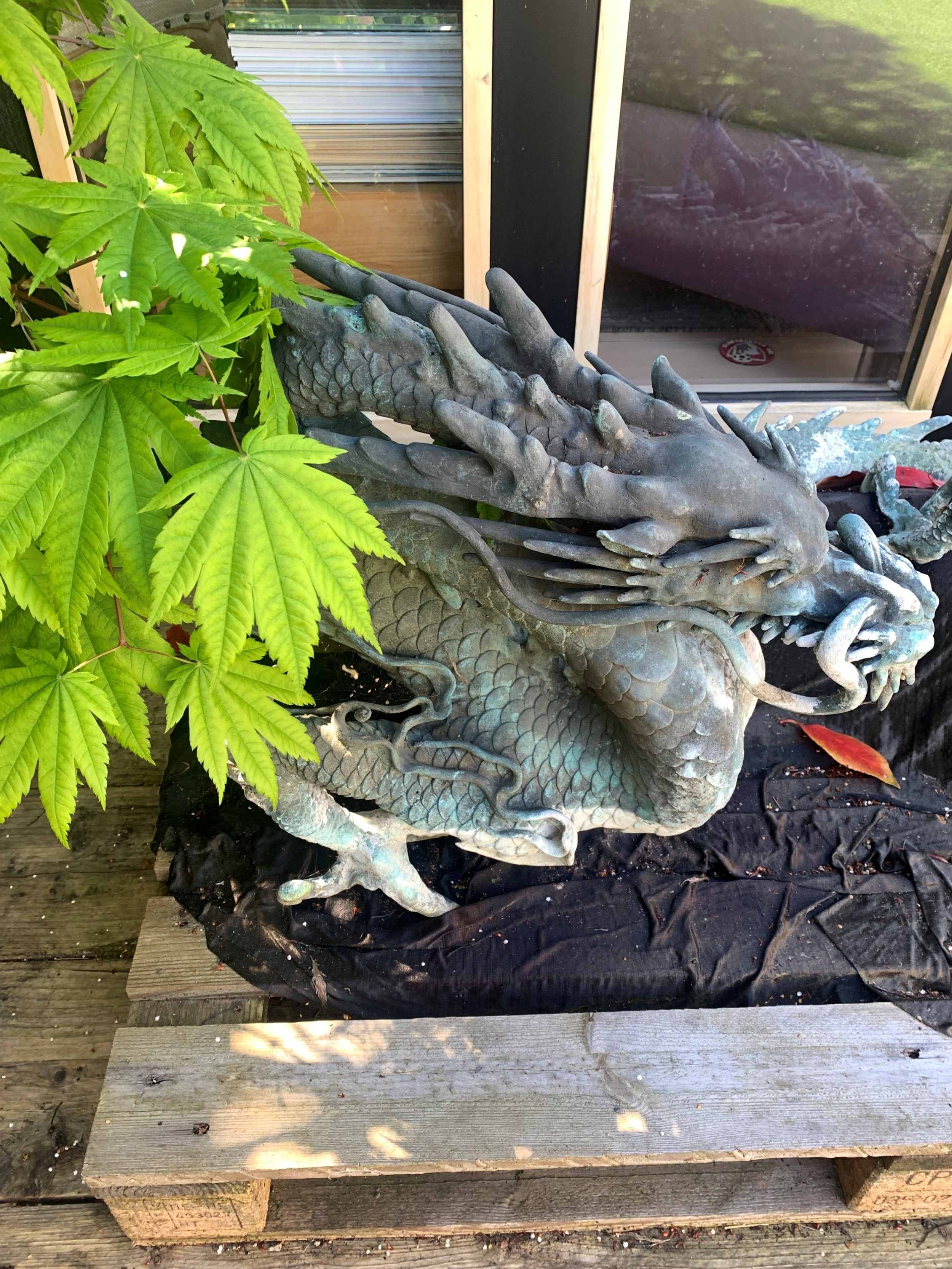 A large patinated bronze Japanese dragon sculpture with detailed chiselled scales and claws resting on a flat surface. View VI