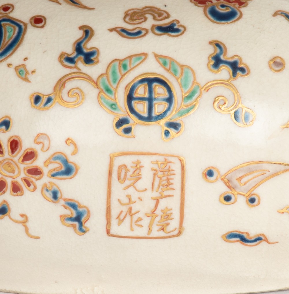 A Japanese Satsuma earthenware okimono depicting the deity Daikoku seated with a mallet and sack, decorated with detailed enamels and gilding. View III