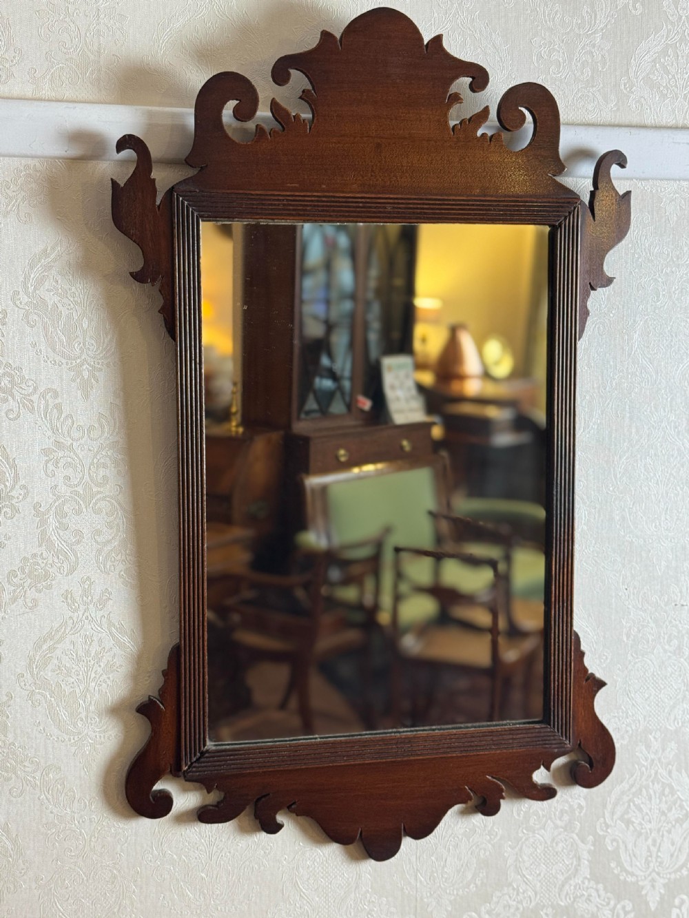 A mahogany Chippendale style wall mirror featuring intricate fretwork scrollwork on the top crest and bottom apron. View IV