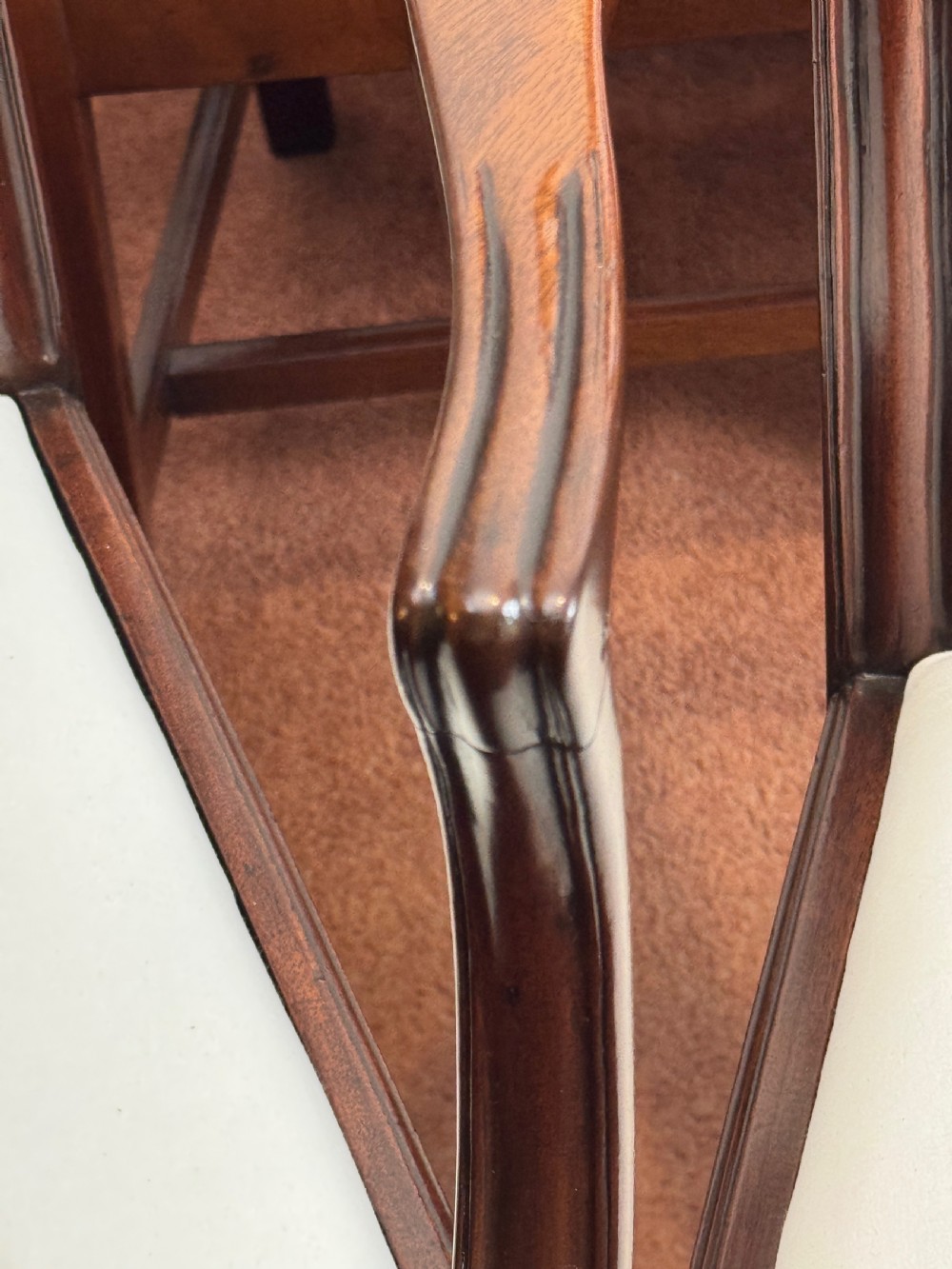 A set of seven mahogany dining chairs with carved vertical splat backs, including six side chairs and one carver armchair with cream fabric seats. View VII