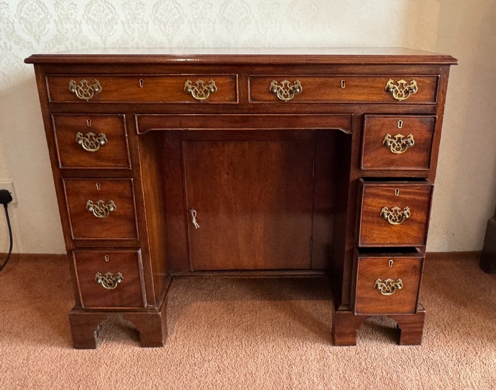 An 18th-century Georgian mahogany kneehole dressing table featuring multiple drawers with brass handles, a central recessed cupboard, and bracket feet. View II