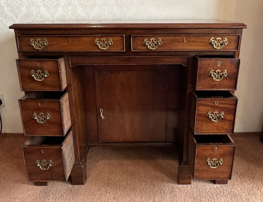 An 18th-century Georgian mahogany kneehole dressing table featuring multiple drawers with brass handles, a central recessed cupboard, and bracket feet. View III