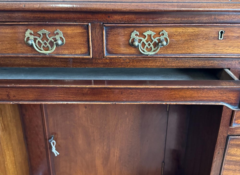 An 18th-century Georgian mahogany kneehole dressing table featuring multiple drawers with brass handles, a central recessed cupboard, and bracket feet. View V