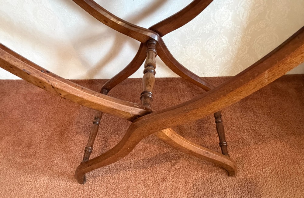 A warm brown wooden antique coaching table featuring a hinged rectangular top supported by curved X-frame legs and turned stretchers. View II