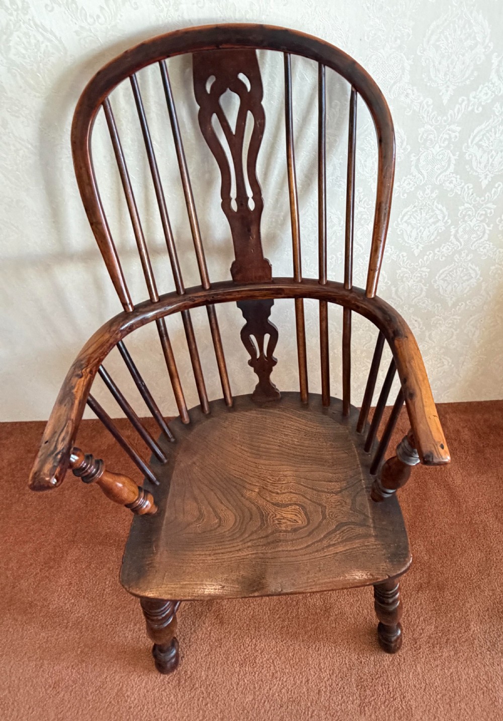 A dark wood high-back Windsor armchair featuring a pierced decorative splat, hoop back, turned leg stretchers, and shaped arm supports. View III