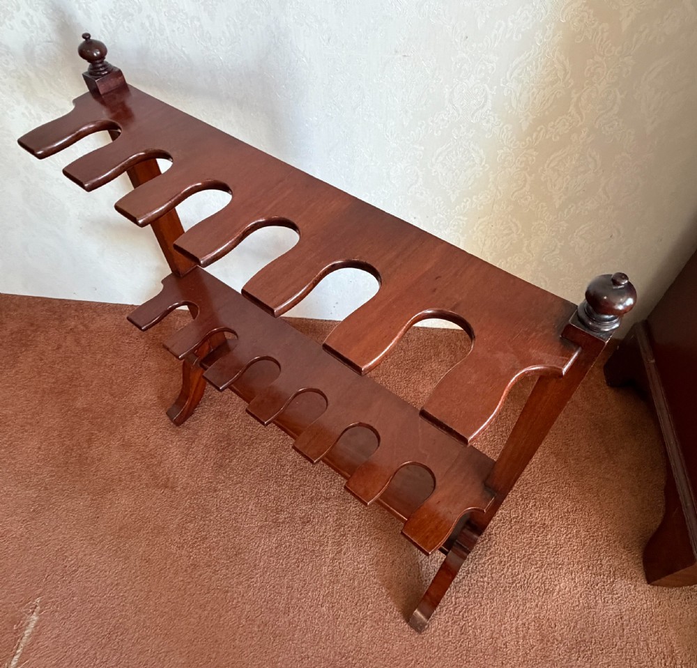 A mahogany wooden boot and whip stand featuring two notched horizontal tiers, top finials, and a lower shelf on curved feet. View V