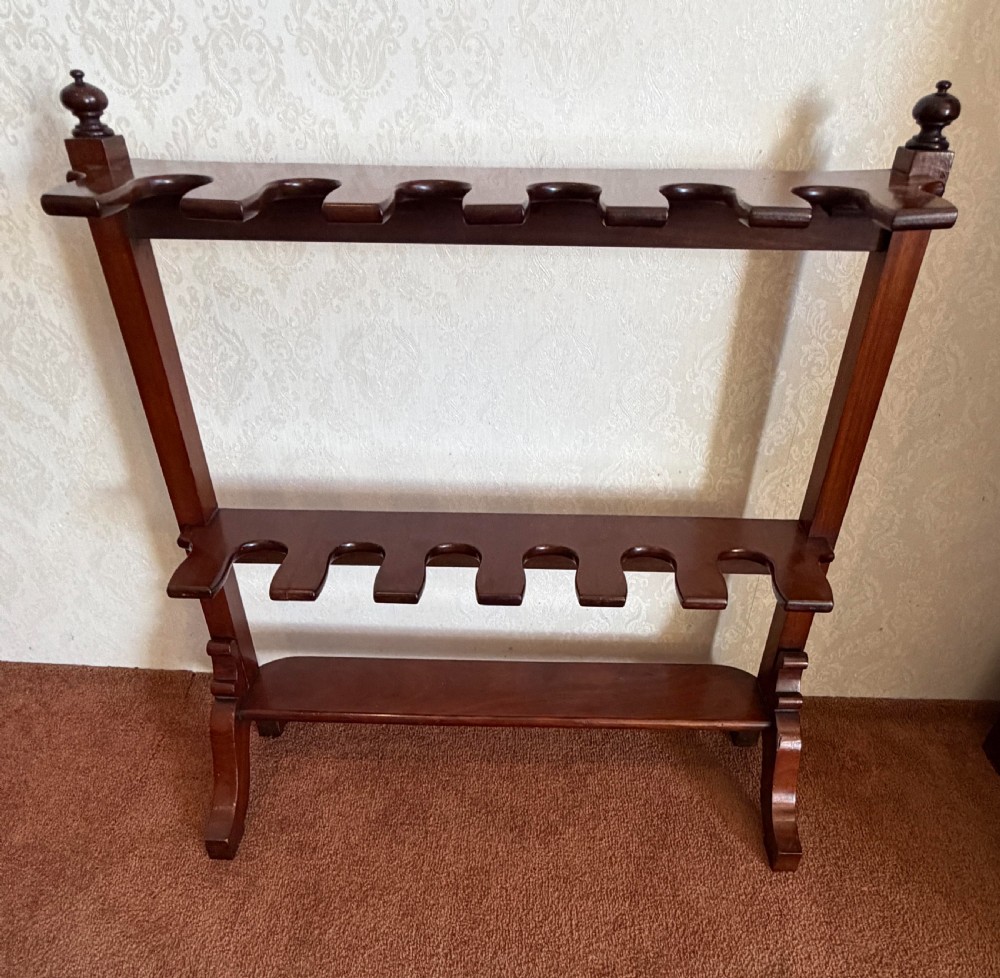 A mahogany wooden boot and whip stand featuring two notched horizontal tiers, top finials, and a lower shelf on curved feet. View VI