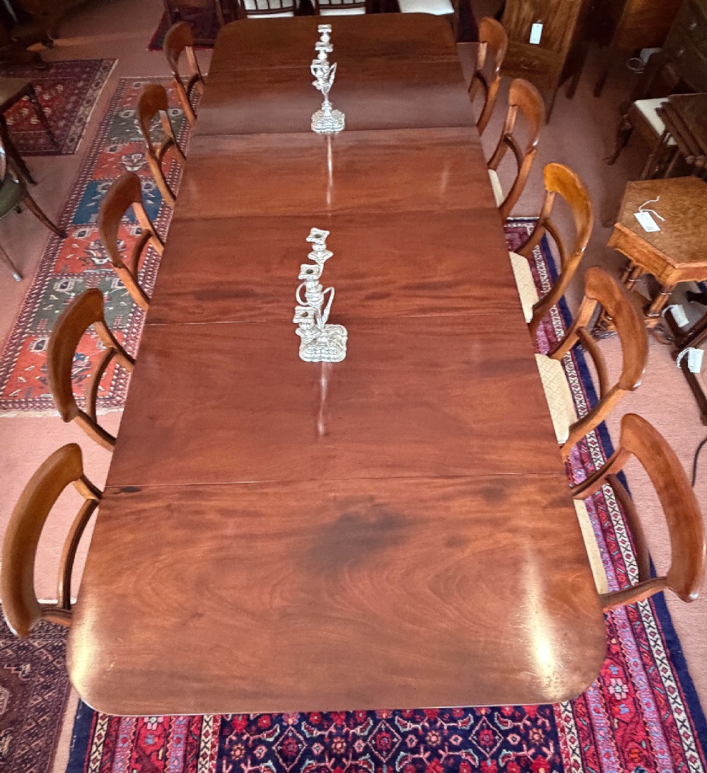 A large mahogany extending dining table with additional inserted leaves, turned legs, and brass castors. View III