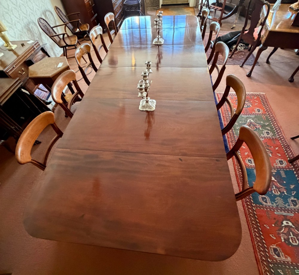 A large mahogany extending dining table with additional inserted leaves, turned legs, and brass castors. View IV