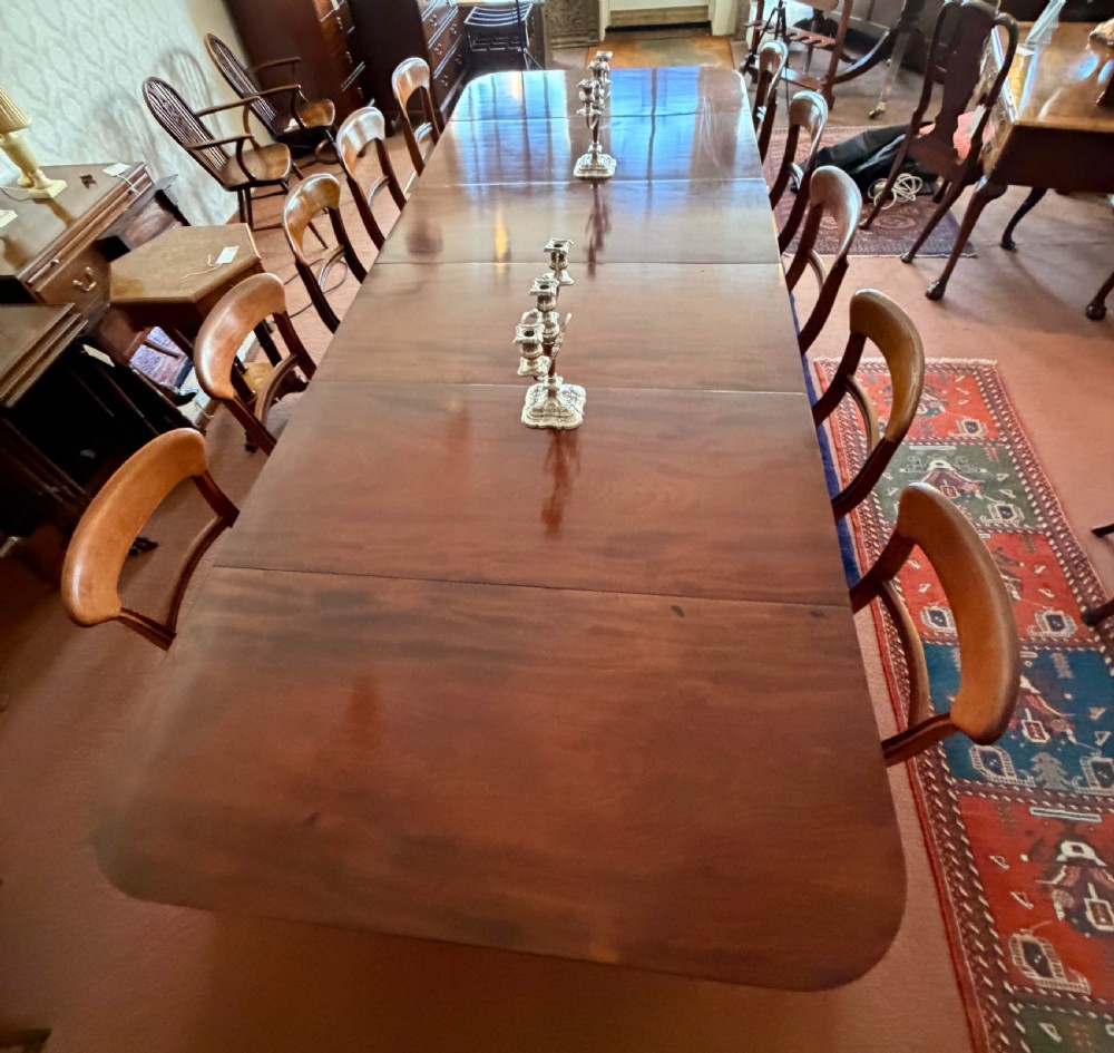 A large mahogany extending dining table with additional inserted leaves, turned legs, and brass castors. View V