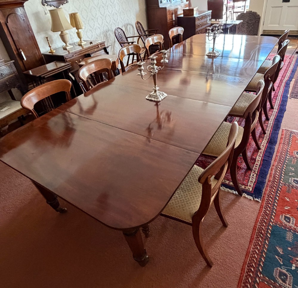 A large mahogany extending dining table with additional inserted leaves, turned legs, and brass castors. View VI