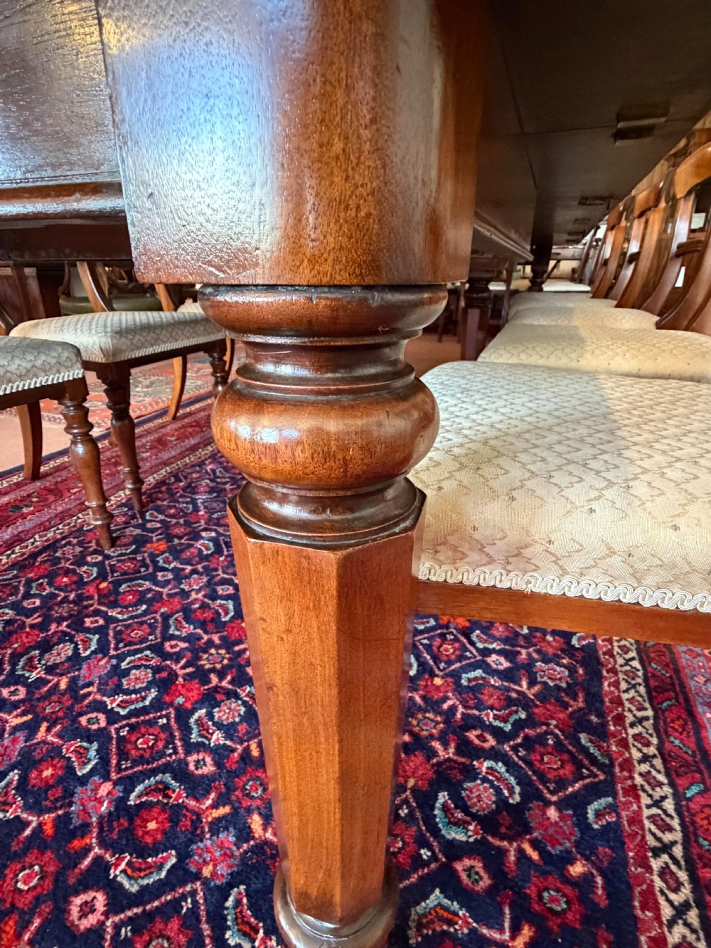 A large mahogany extending dining table with additional inserted leaves, turned legs, and brass castors. View VIII