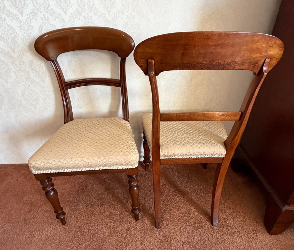 A mahogany dining chair featuring a curved top rail, horizontal bar back, turned front legs, and a beige patterned upholstered seat. View VI