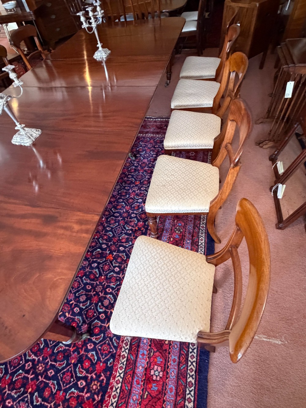 A mahogany dining chair featuring a curved top rail, horizontal bar back, turned front legs, and a beige patterned upholstered seat. View VIII