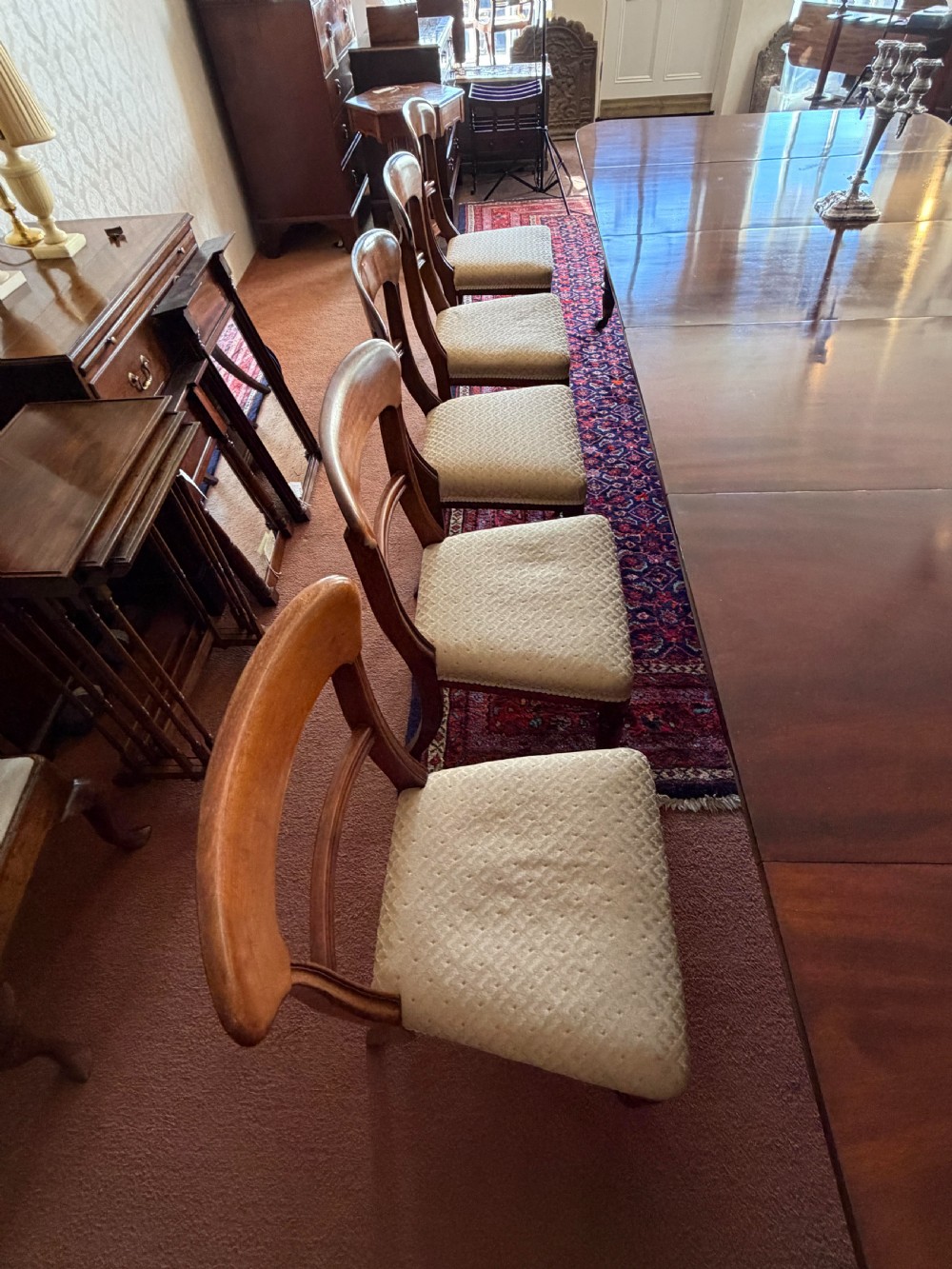 A mahogany dining chair featuring a curved top rail, horizontal bar back, turned front legs, and a beige patterned upholstered seat. View IX