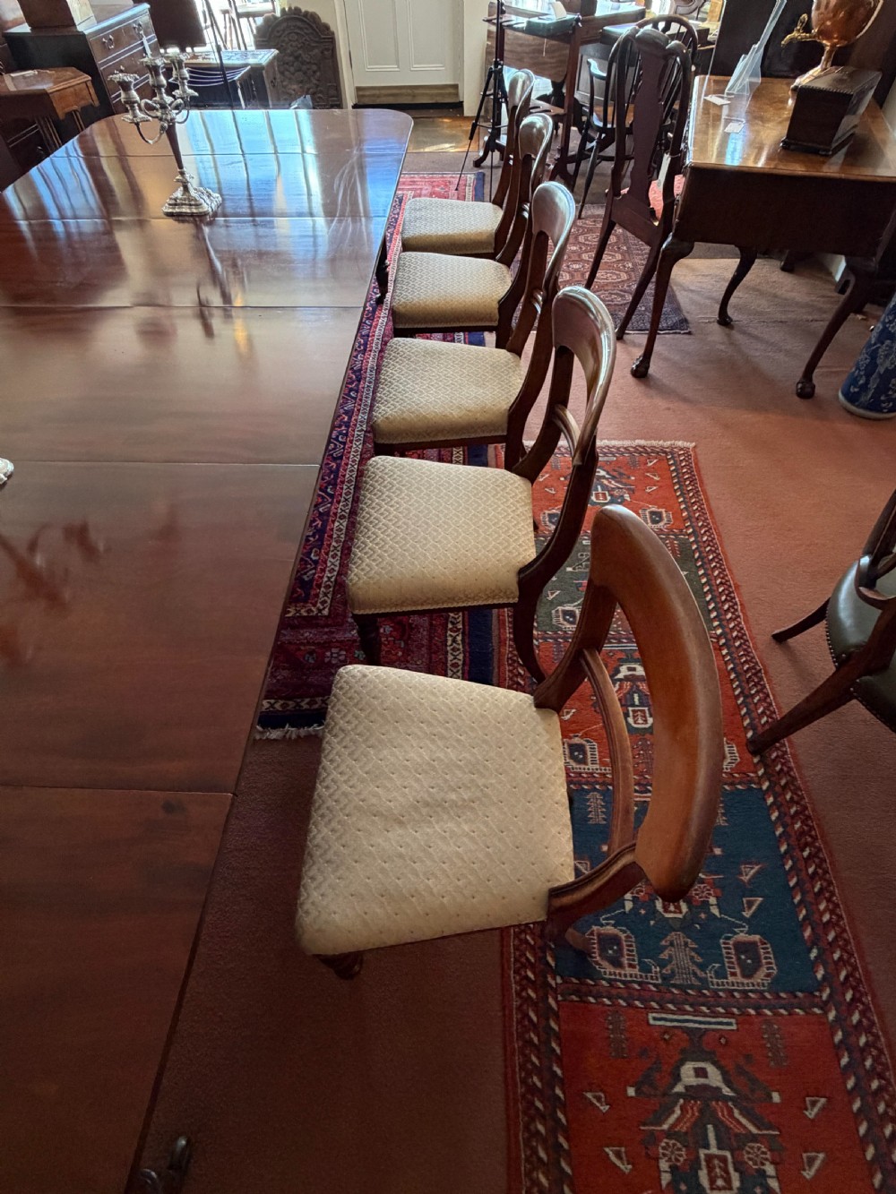A mahogany dining chair featuring a curved top rail, horizontal bar back, turned front legs, and a beige patterned upholstered seat. View XI