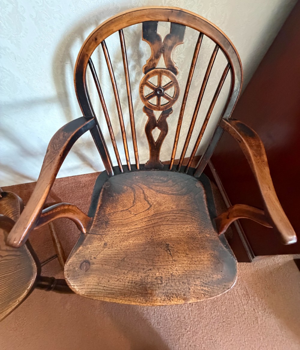 A near pair of wooden wheelback Windsor armchairs with curved hoops, turned legs, and carved central back splats. View IV