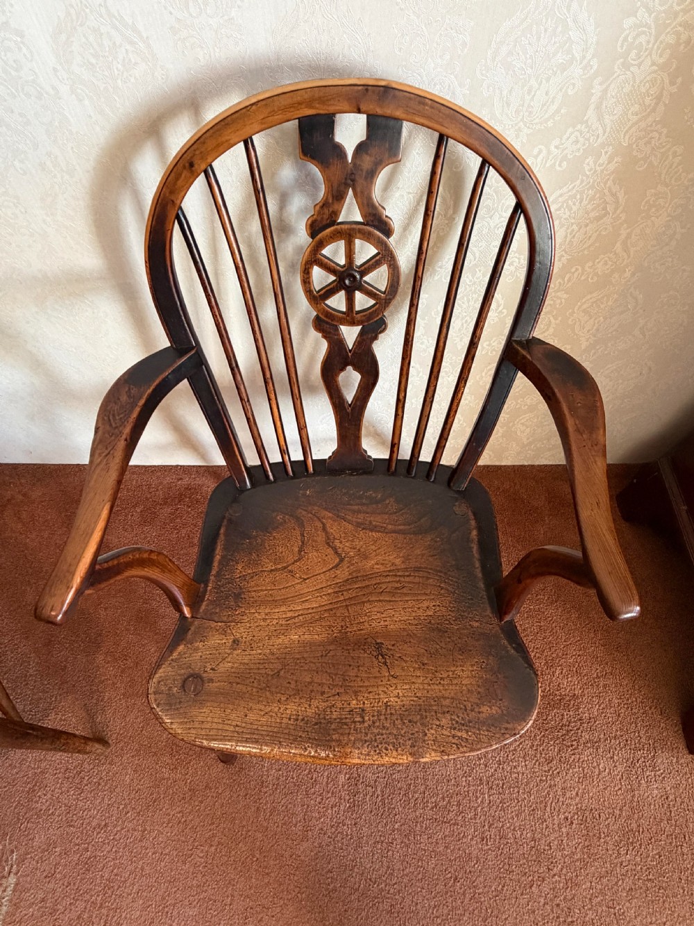 A near pair of wooden wheelback Windsor armchairs with curved hoops, turned legs, and carved central back splats. View VI