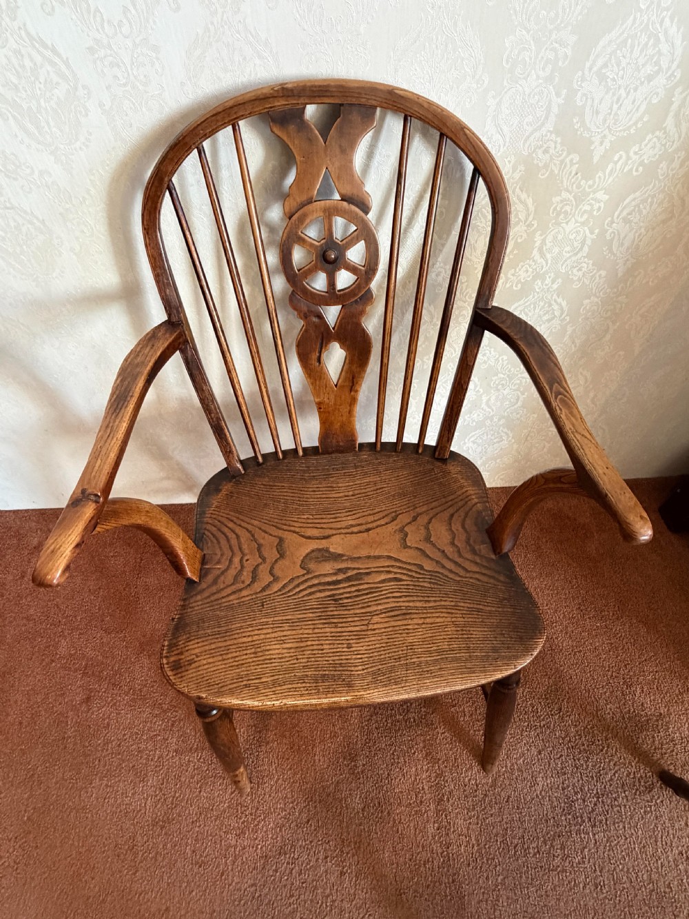 A near pair of wooden wheelback Windsor armchairs with curved hoops, turned legs, and carved central back splats. View VII