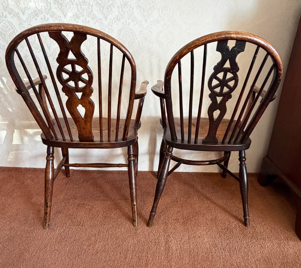 A near pair of wooden wheelback Windsor armchairs with curved hoops, turned legs, and carved central back splats. View VIII