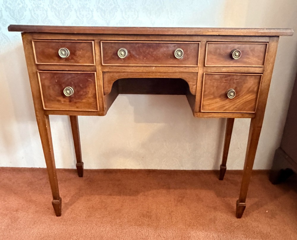 A Georgian mahogany Pembroke side table featuring two hinged drop leaves, a single drawer with brass knobs, string-inlaid square tapered legs, and brass castors. View VII