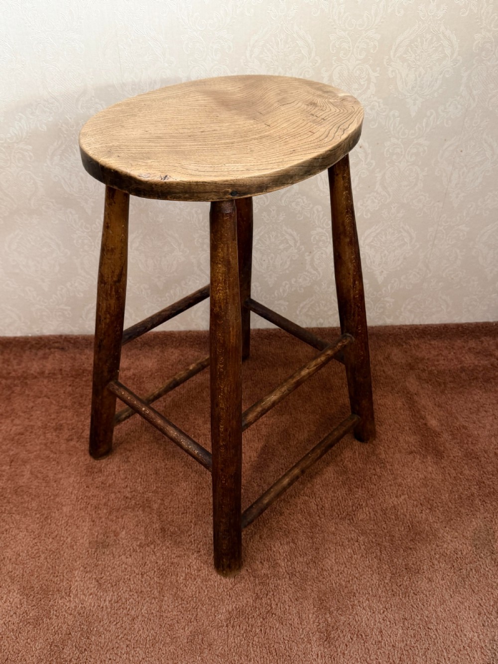 A rustic vintage ash stool featuring a circular solid wood seat mounted on four tapered turned legs joined by simple side stretchers. View II