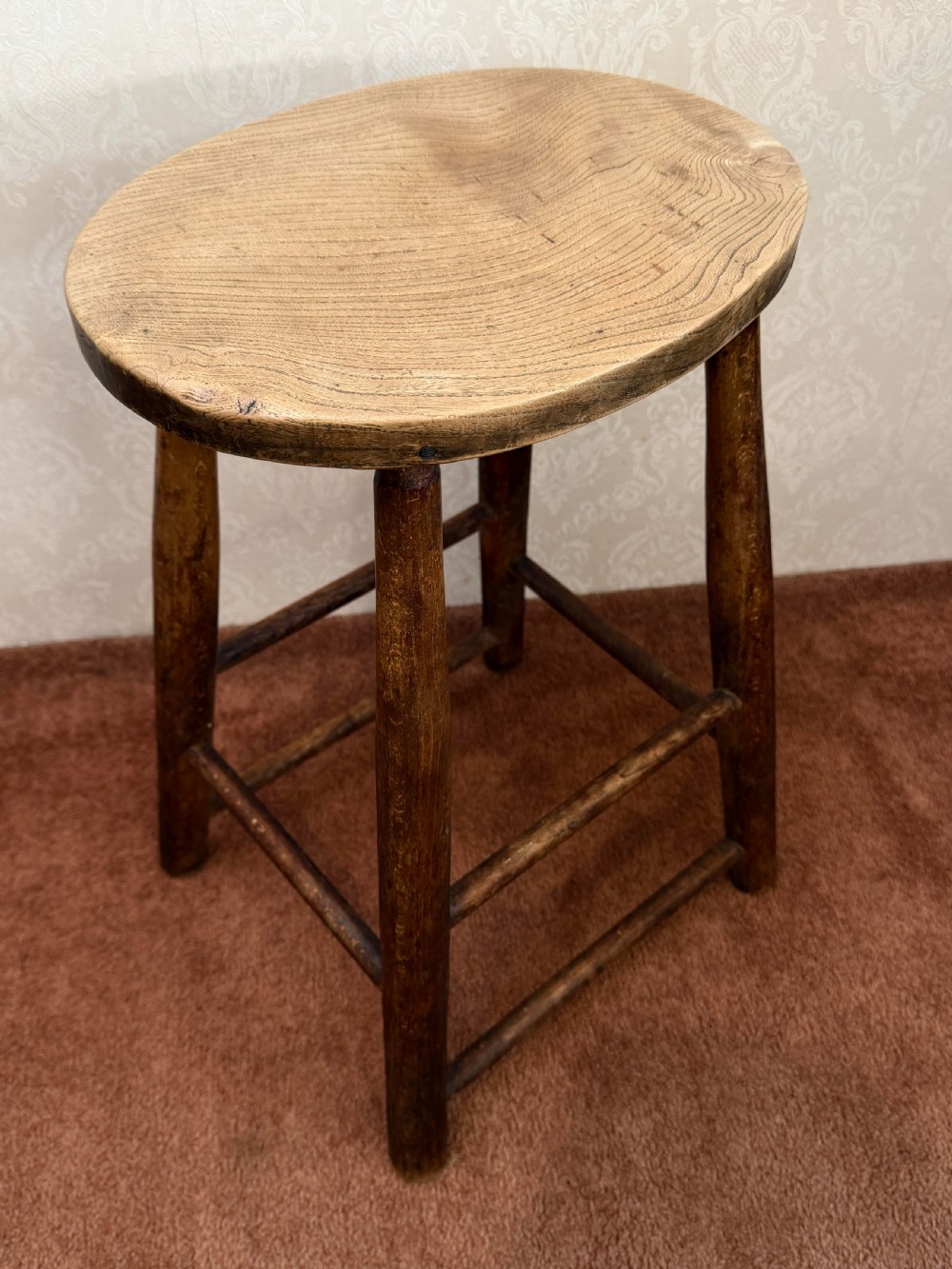 A rustic vintage ash stool featuring a circular solid wood seat mounted on four tapered turned legs joined by simple side stretchers. View III