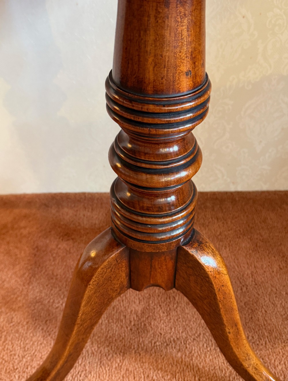 A Georgian mahogany tripod table featuring a rounded rectangular tilt-top surface, a ring-turned central pedestal, and three downswept legs. View II