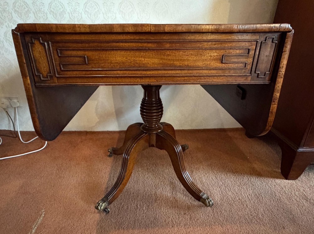 A Regency mahogany drop leaf breakfast table with a reeded central pedestal support and four splayed sabre legs with brass paw castors. View VII