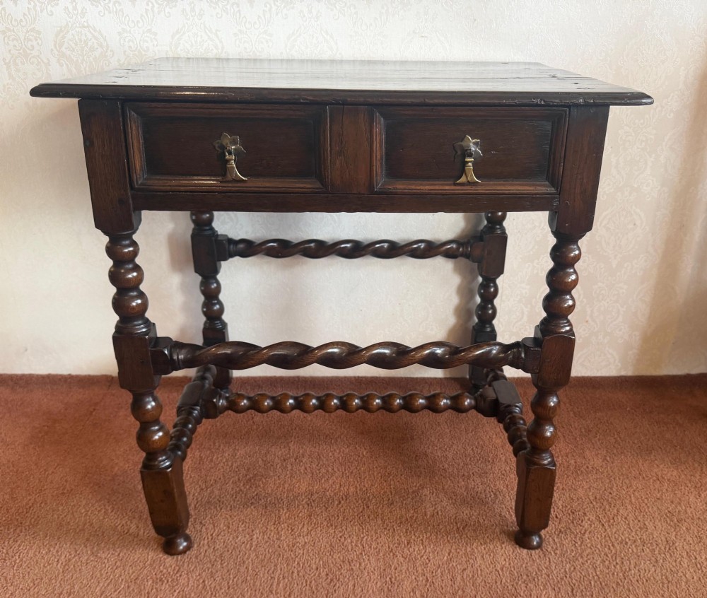 A dark oak side table featuring bobbin-turned legs, barley twist stretchers, and two drawers with brass handles. View II