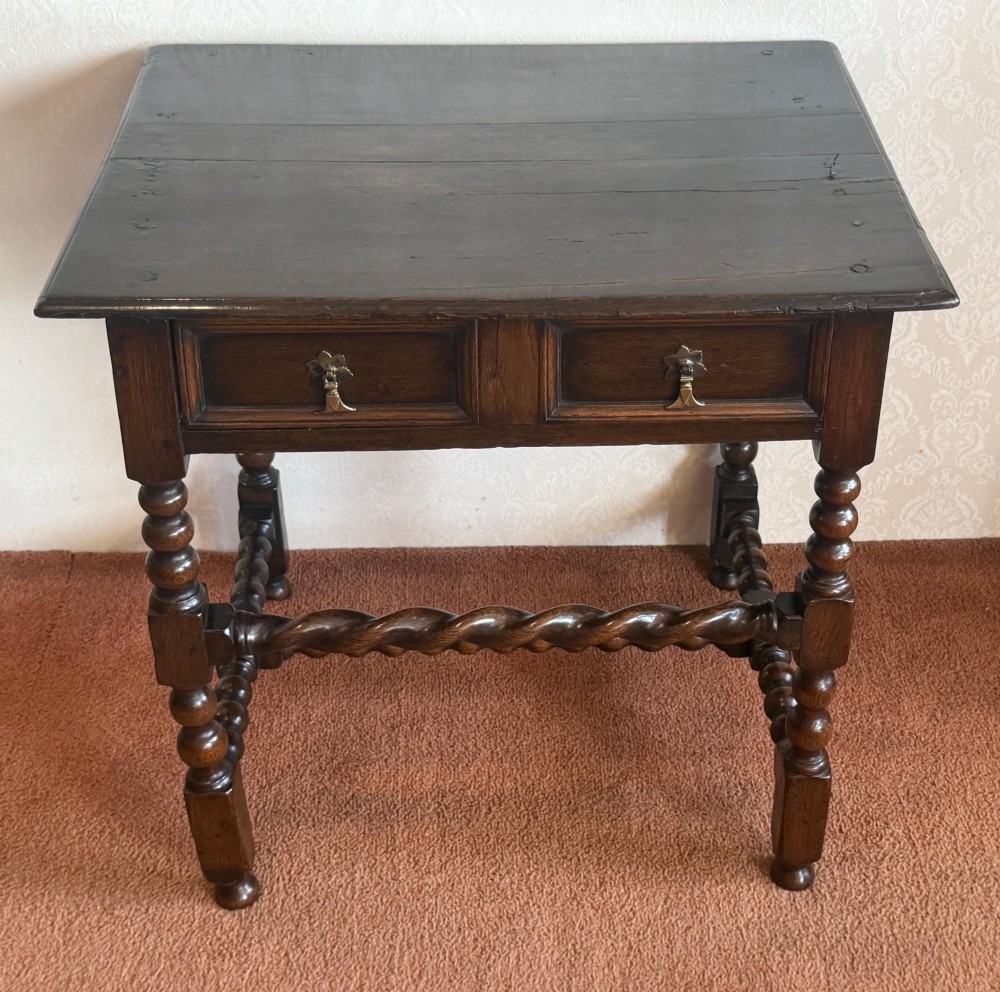 A dark oak side table featuring bobbin-turned legs, barley twist stretchers, and two drawers with brass handles. View VI