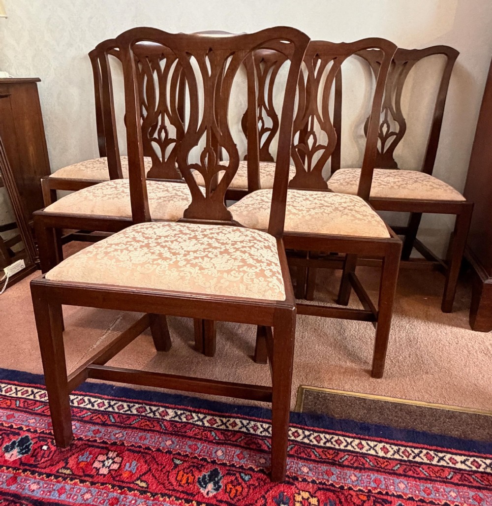 A mid-18th-century mahogany dining chair featuring a carved pierced back splat, serpentine crest rail, and a patterned damask drop-in seat. View V