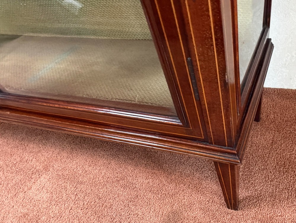 A late nineteenth-century mahogany display cabinet featuring twin glazed doors, floral marquetry frieze inlay, glass side panels, and square tapered legs. View VII
