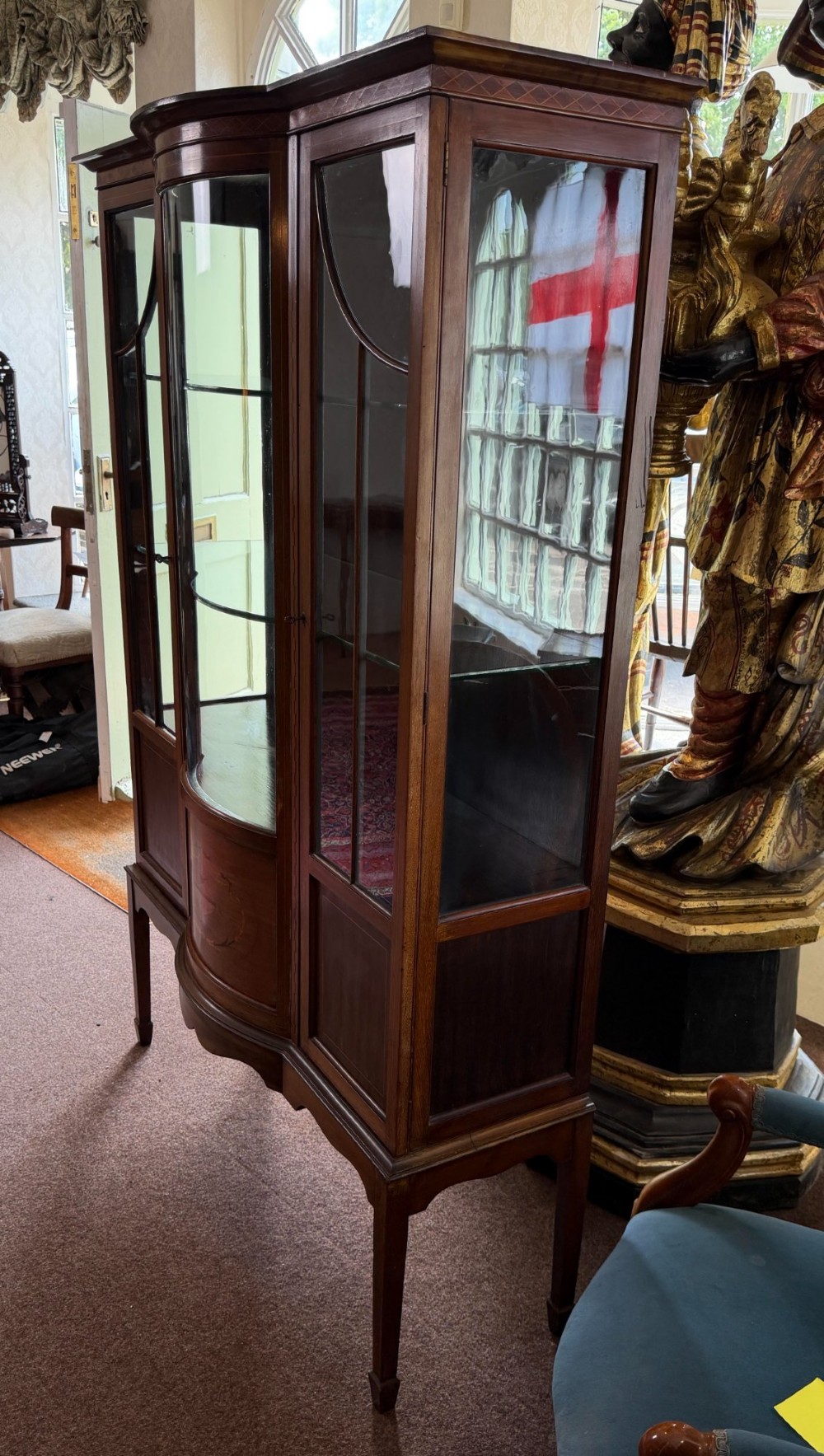A late Victorian mahogany bow-front display cabinet featuring glazed doors, detailed marquetry inlay, and raised square tapered legs. View III
