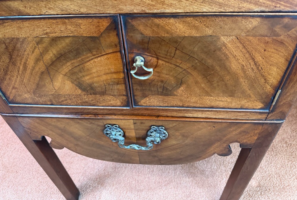 Mid-18th century Georgian mahogany bedside cabinet featuring a tray top gallery with cut-out handholds, double cupboard doors, lower drawer, and square legs. View II