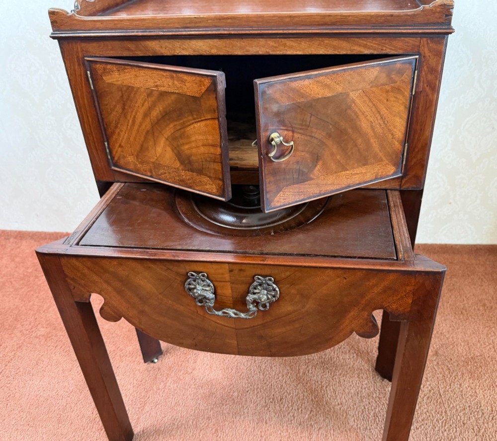 Mid-18th century Georgian mahogany bedside cabinet featuring a tray top gallery with cut-out handholds, double cupboard doors, lower drawer, and square legs. View IV